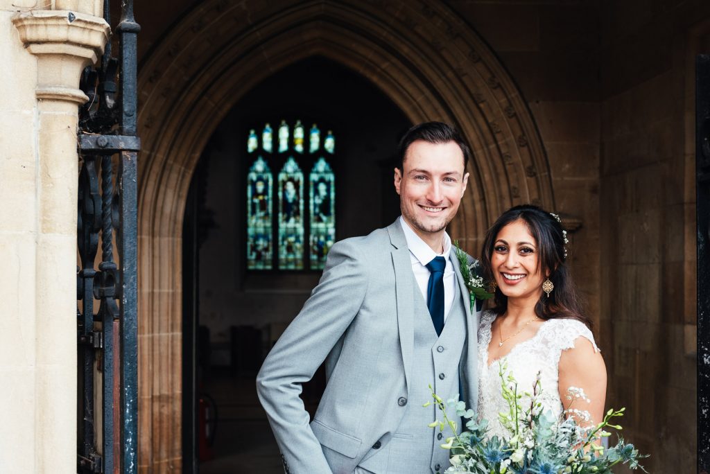 Newly married couple stand outside the church together