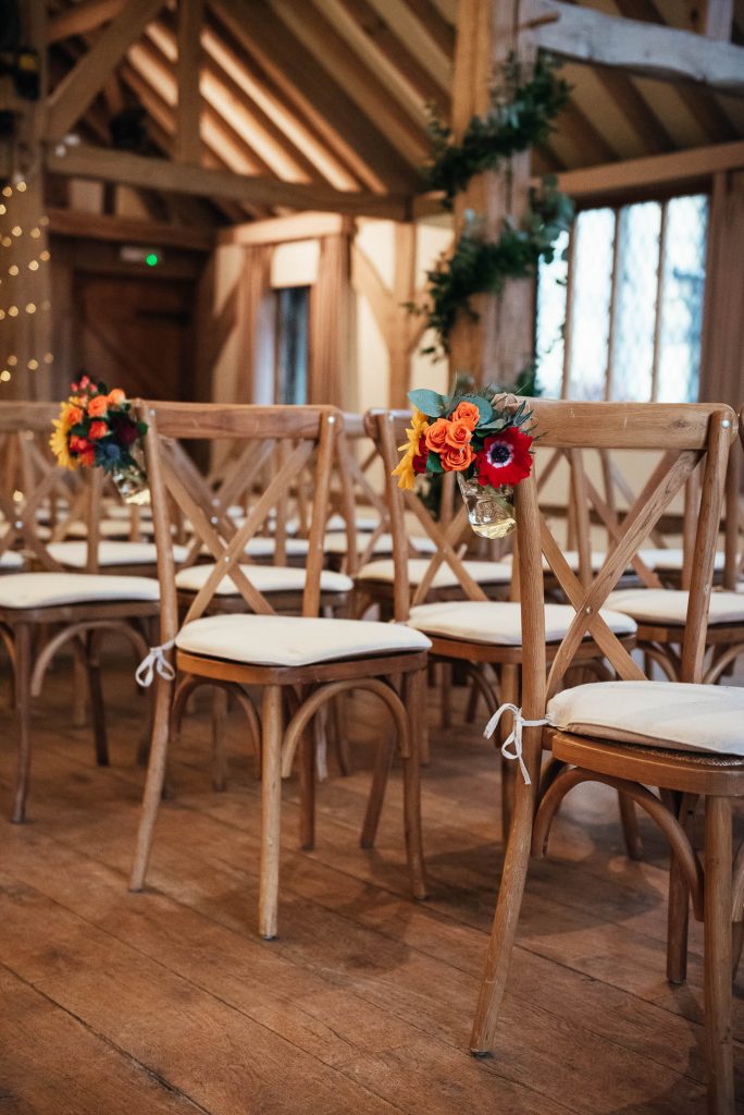Cain Manor wedding venue with wooden chairs and autumnal florals 