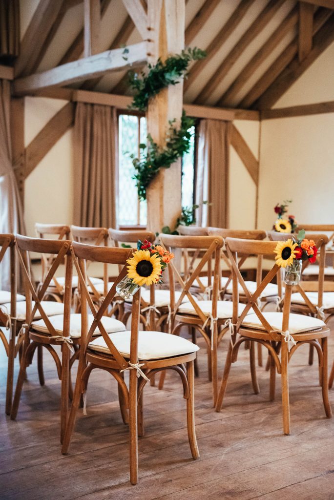 Cain Manor wedding venue with wooden chairs and autumnal florals 