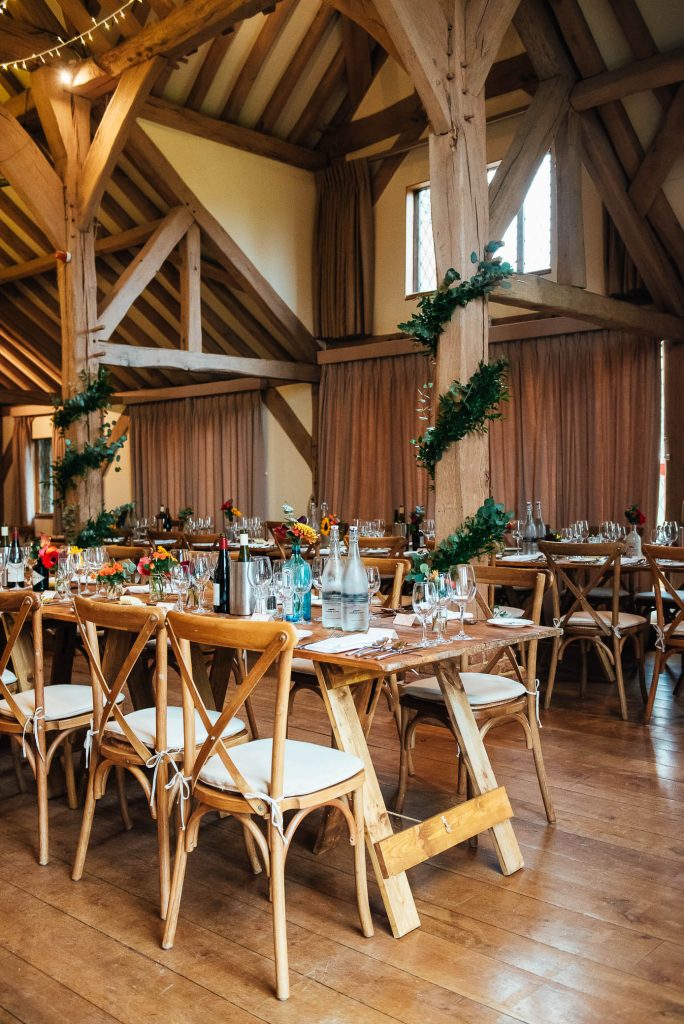 Cain Manor wedding breakfast room decorated with green foliage and candles