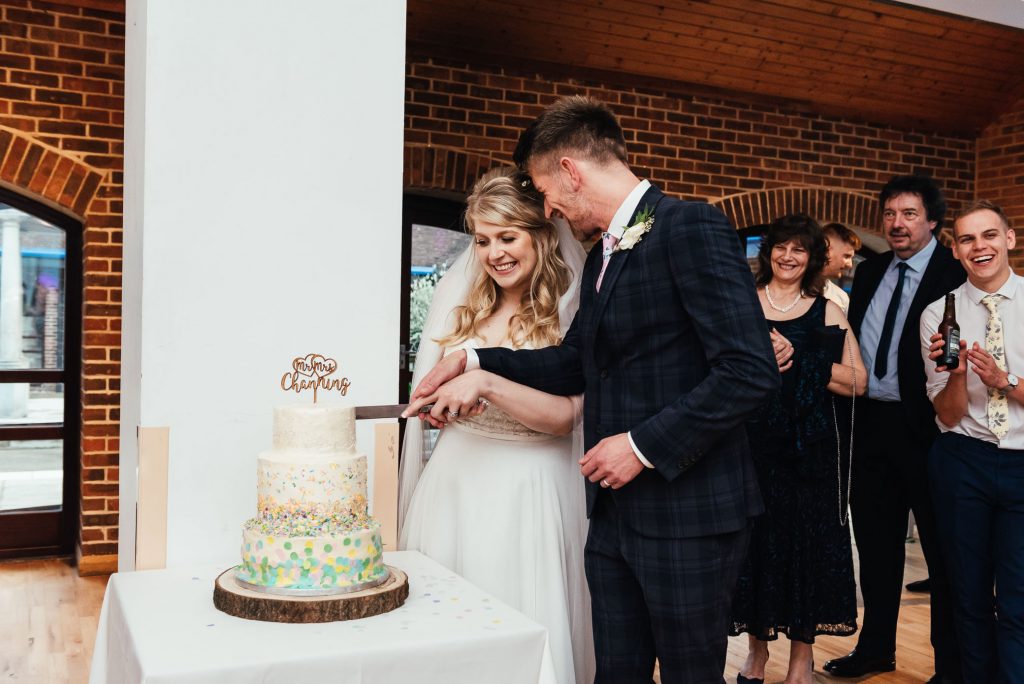 Bride and groom cut the wedding cake together Denbies Wine Estate Wedding