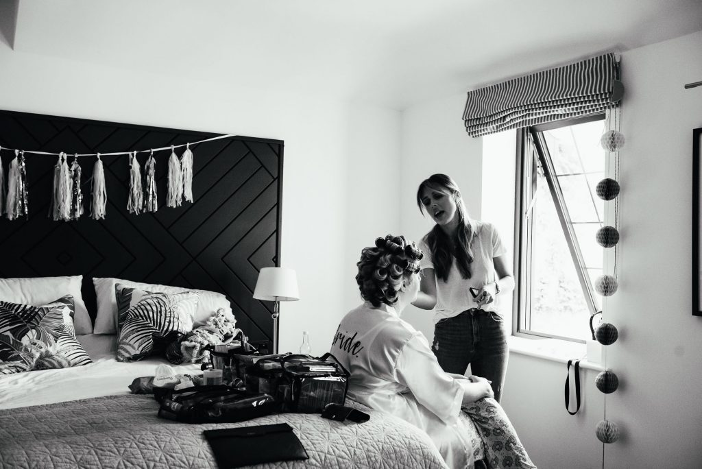 Black and white image of bride having her make up applied