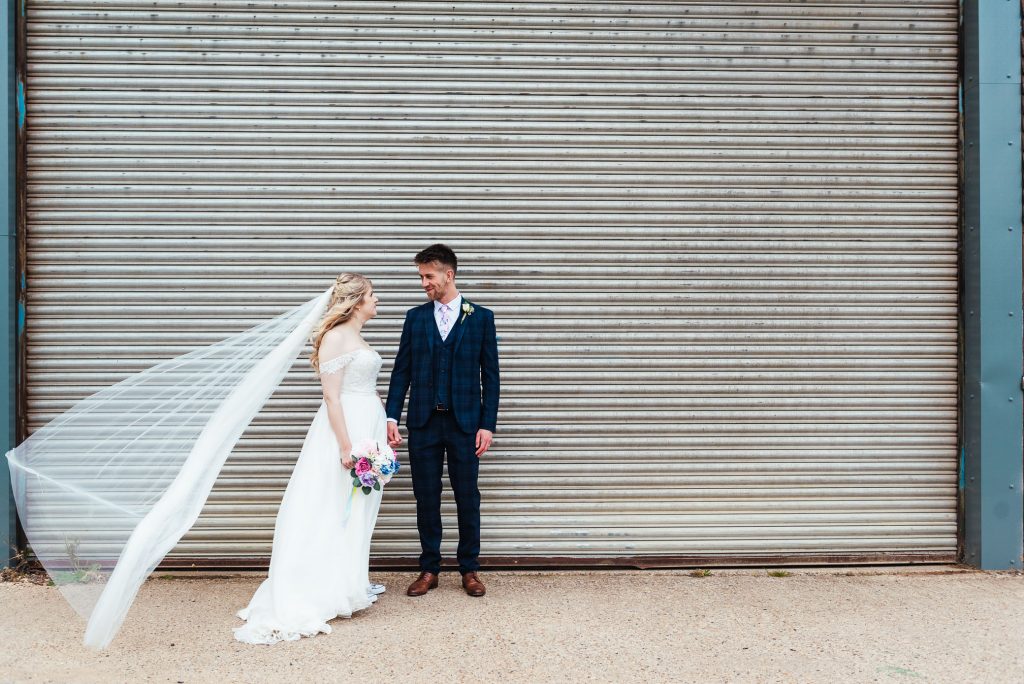 Artistic wedding portrait with couple in front of garage door