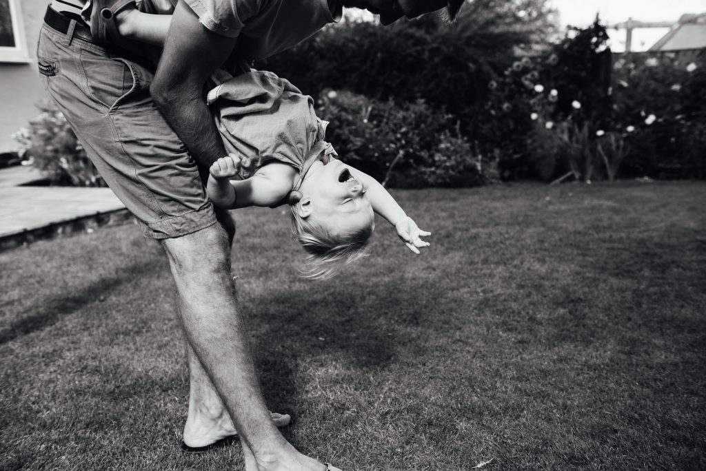 Black and white photograph of a daughter playing with her father