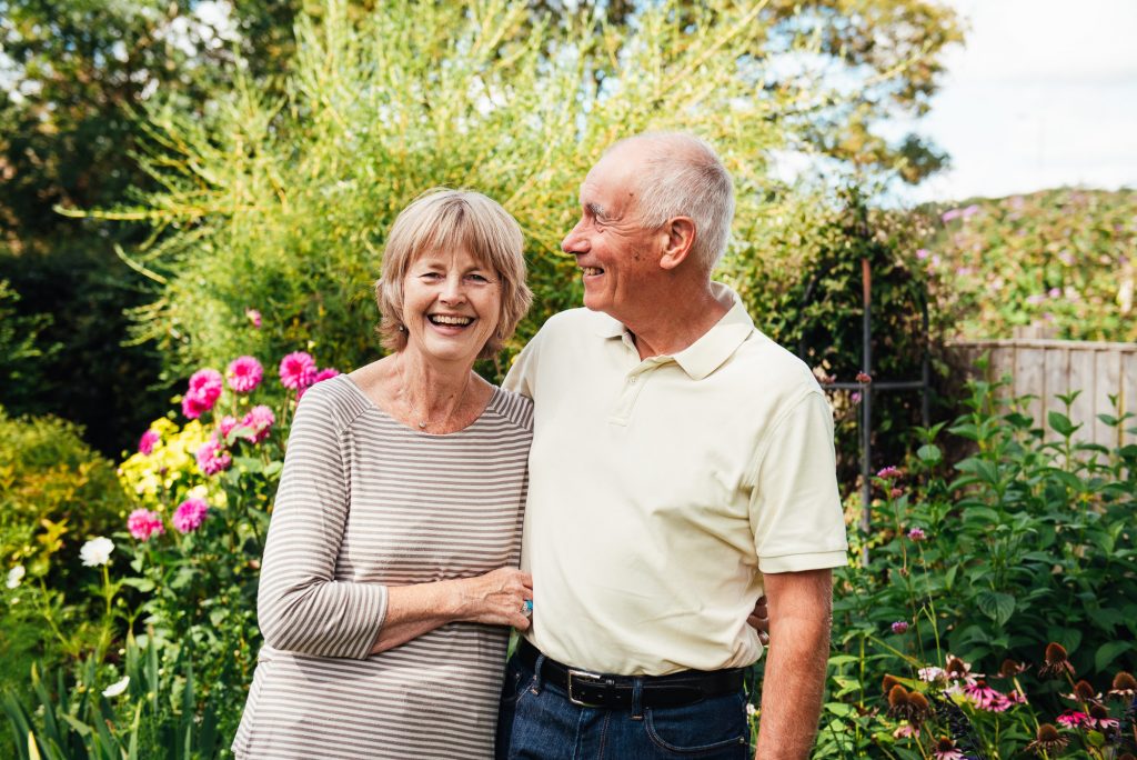 Grandparents smile and laugh together in outdoor family photoshoot
