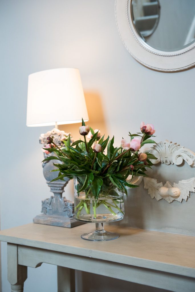 Peony flowers upon a white stained wood mantlepiece