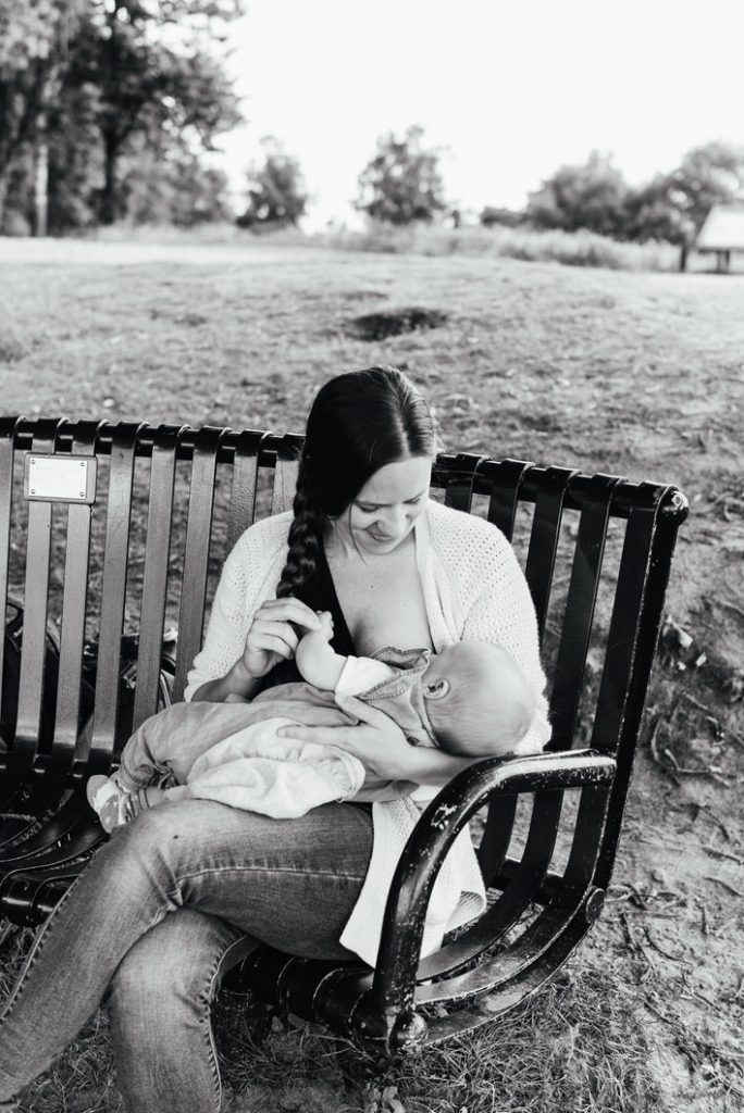 Mother breastfeeding baby outdoors