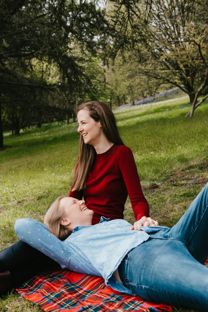 Couple Sit Together on Picnic Rug Smiling, LGBT engagement shoot
