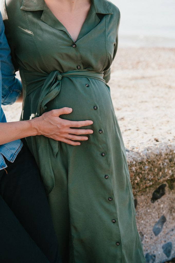 Loving hands placed on baby bump in maternity shoot