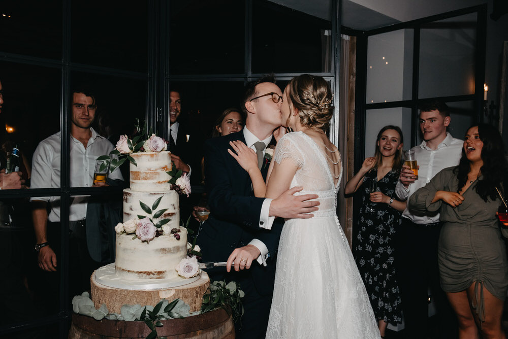 Couple Kiss Cutting the Cake
