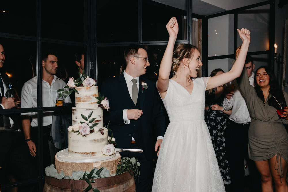 Bride and Groom Cheer as They Cut The Cake