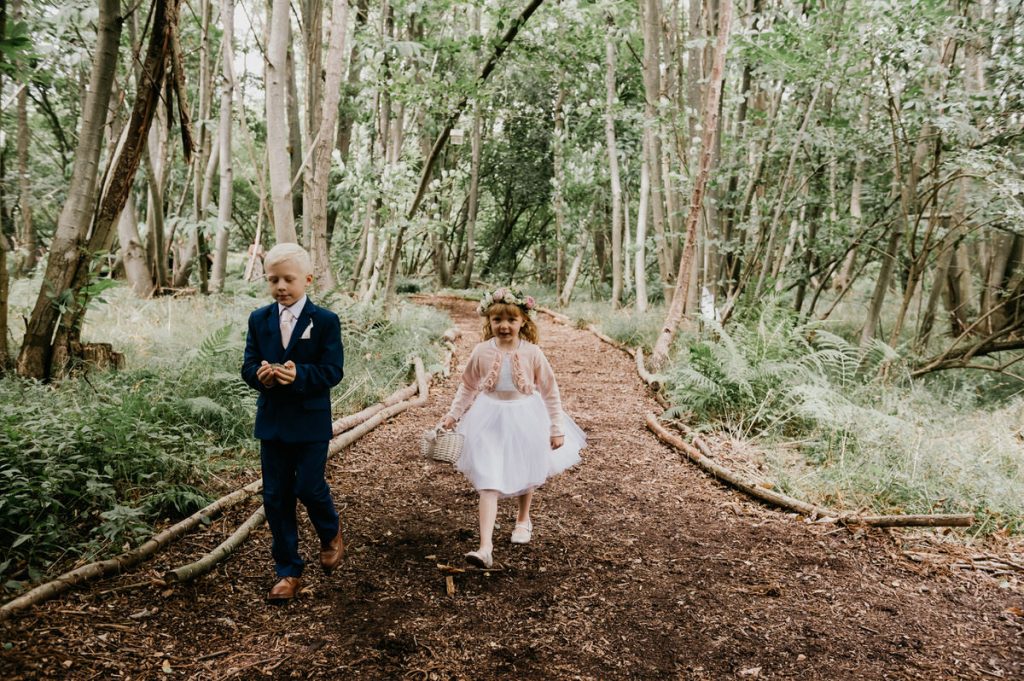 Page Boy and Flower Girl Walk Down Woodland Aisle 