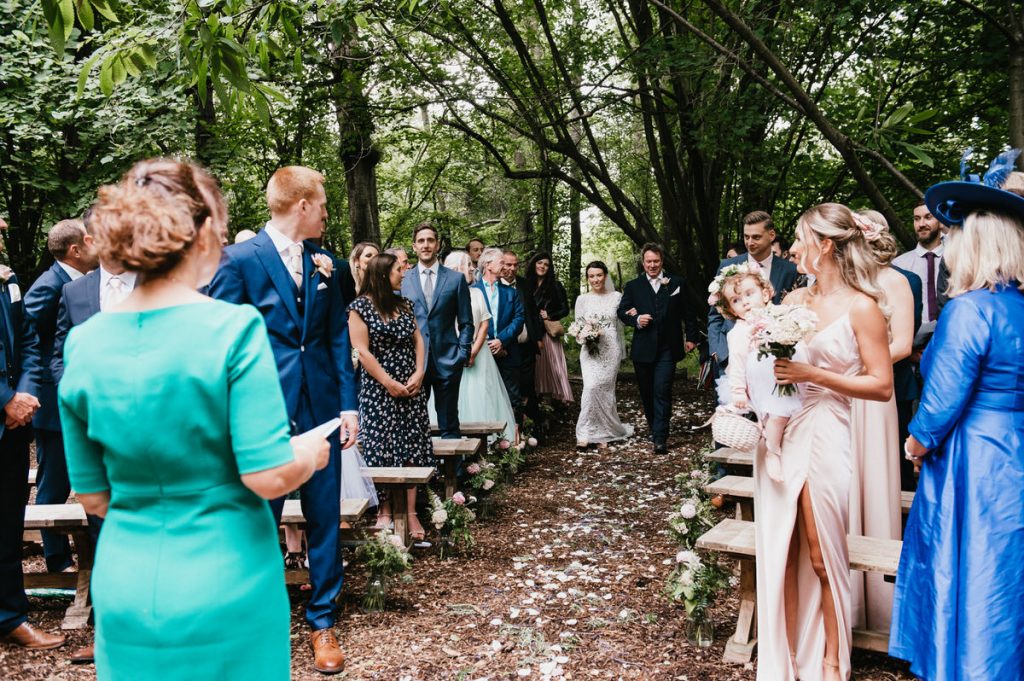 Bride and Father Walk Down Woodland Aisle for Outdoor Gate Street Barn Wedding