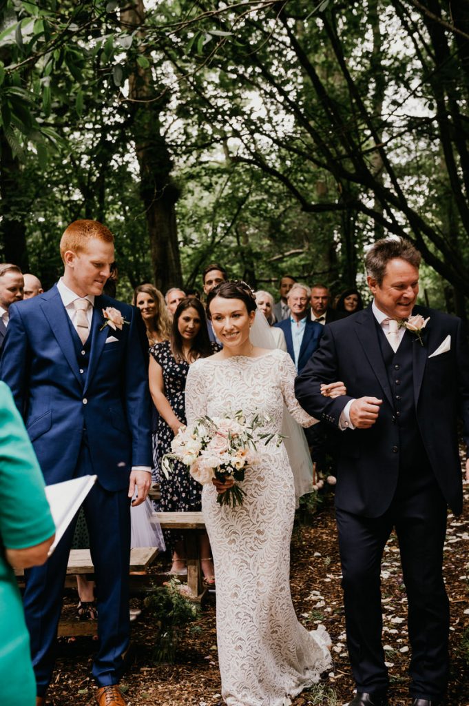 Bride and Father Walk Down Woodland Aisle at Outdoor Gate Street Barn Wedding