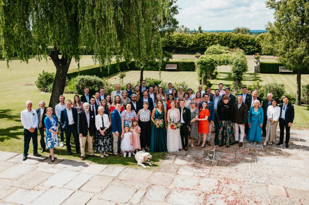 Guests Gather Outside for Summer Cain Manor Wedding Group Photograph