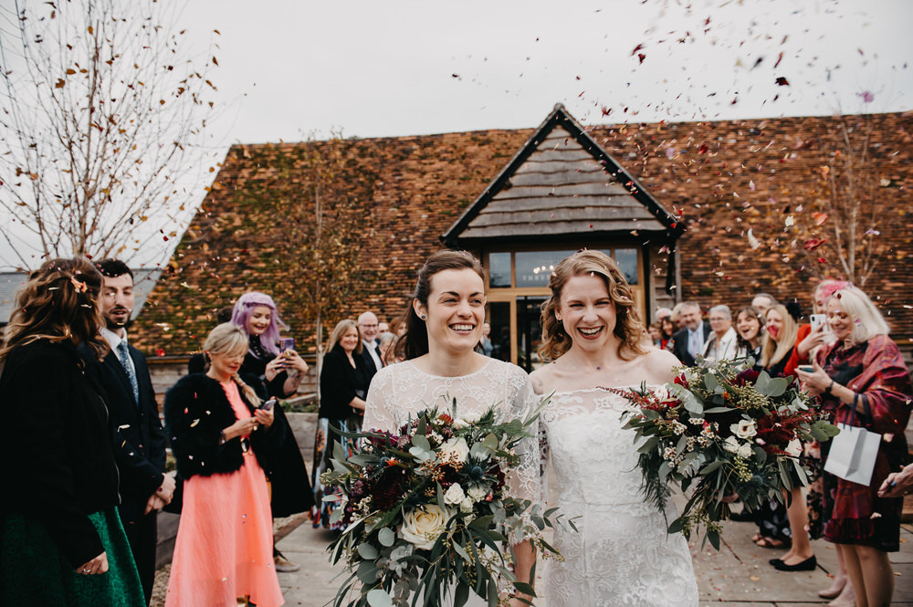 Couple Walk Together Through Confetti Arch - Silchester Farm Wedding