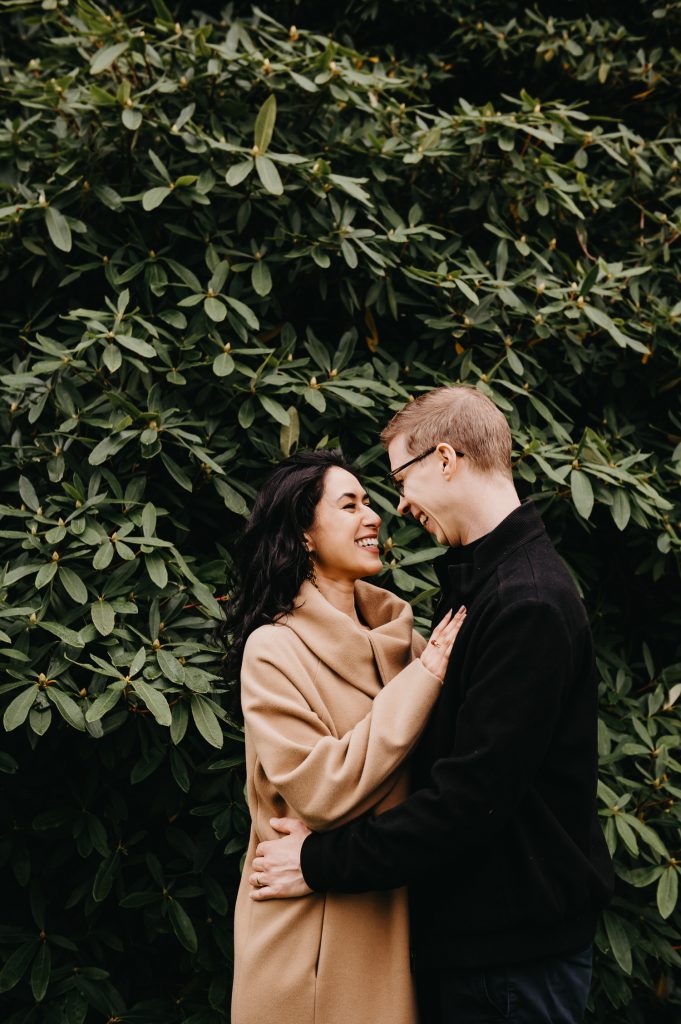 Couple Share Loving looks at One Another in Front of Large Green Foliage