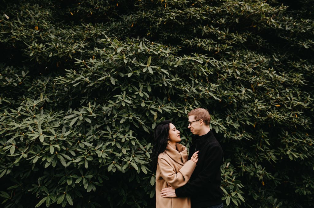 Couple Share Loving looks at One Another in Front of Large Green Foliage