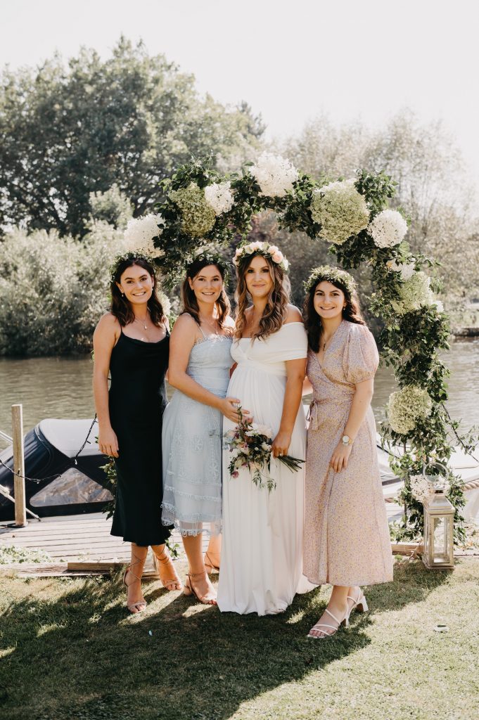 Bride and Sisters Family Portrait in front a Floral Arch