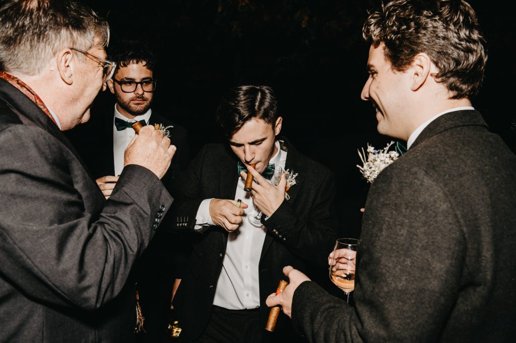 Documentary Evening Photography - Groomsmen Take a Moment With Cigars. 