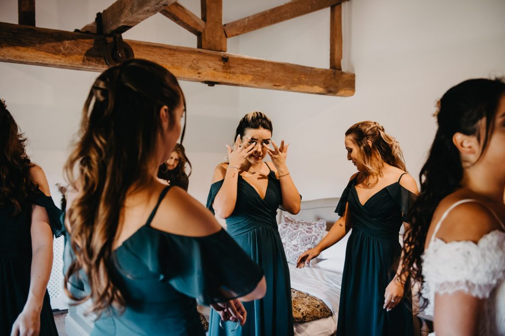 Emotional wedding photography - sister cries upon seeing her sister in her wedding outfit for the first time. 