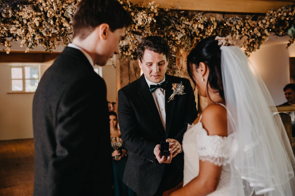 Best man presents wedding ring to couple during ring exchange in the ceremony. 