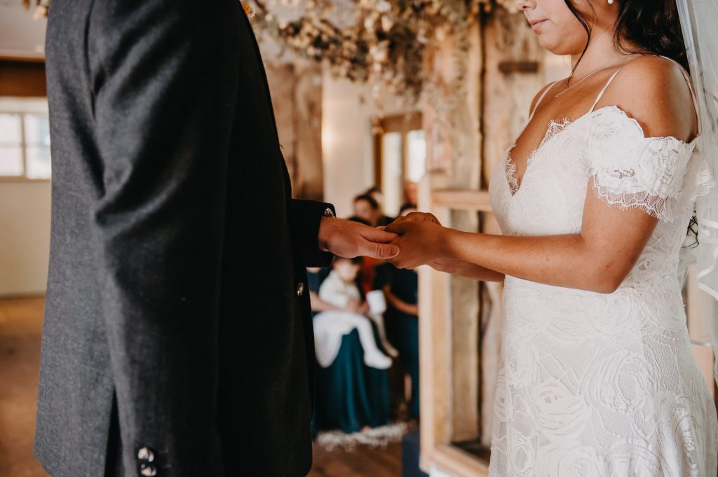 Wedding ring exchange during Bury Court Barn wedding ceremony