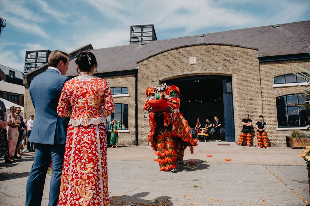Couple Watch Dragon Dance During Chinese Wedding Day Tradition - London Wedding Photography
