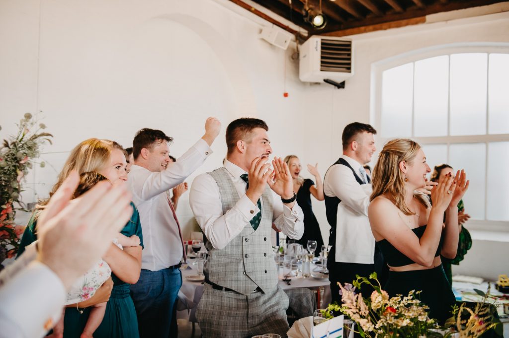 Guests Cheer as Wedding Couple Enter - Trinity Buoy Wharf Wedding
