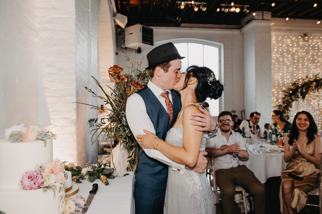 Couple Cut The Cake and Share a Kiss - London Wedding Photography