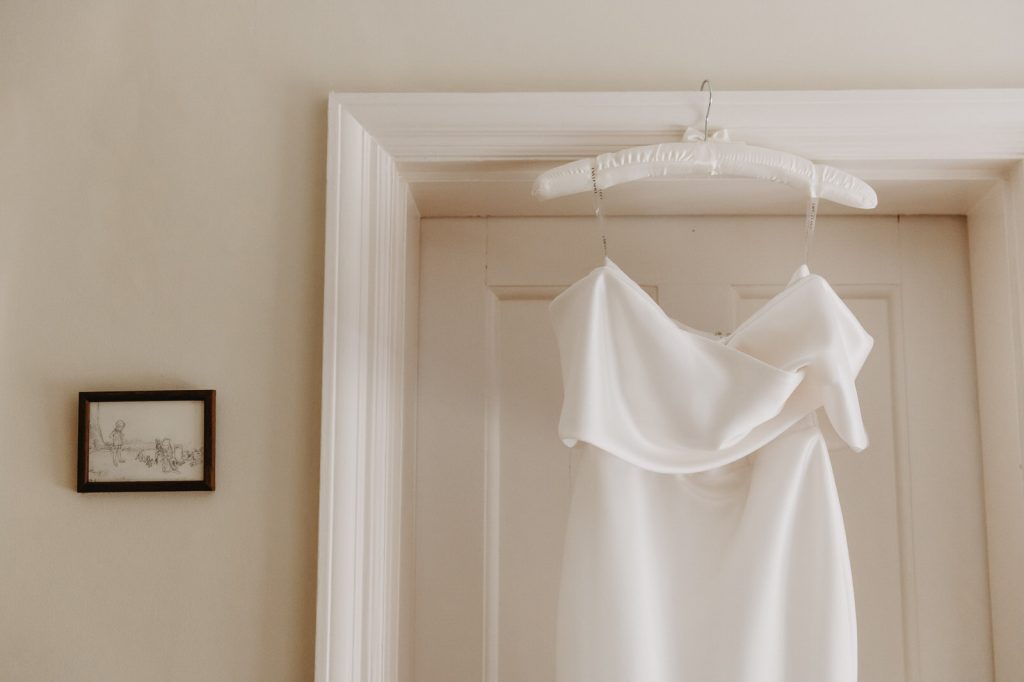 Wedding Dress hangs in door way of family home. 