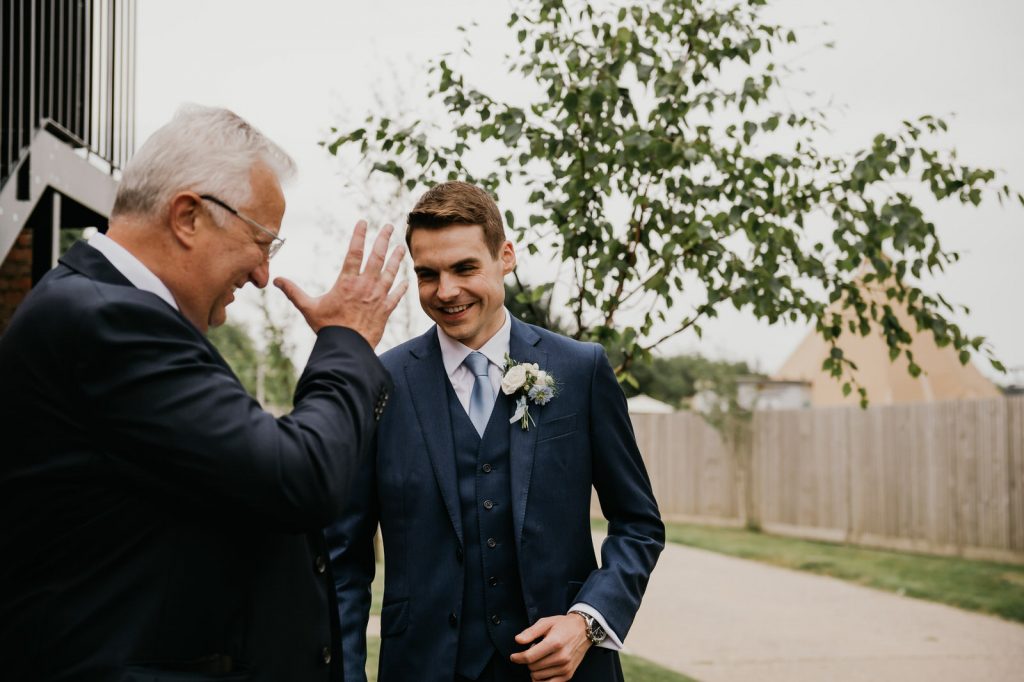 Groom and Father of the bride share a funny and candid moment. 