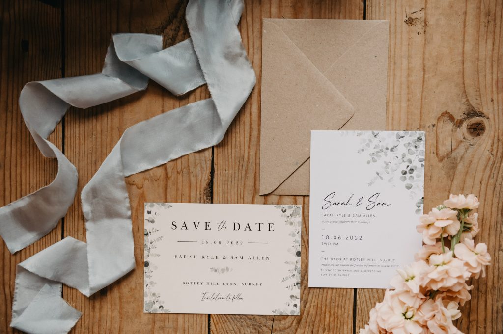 Wedding day details with ribbon decoration surrounding the invitation and save the date cards.