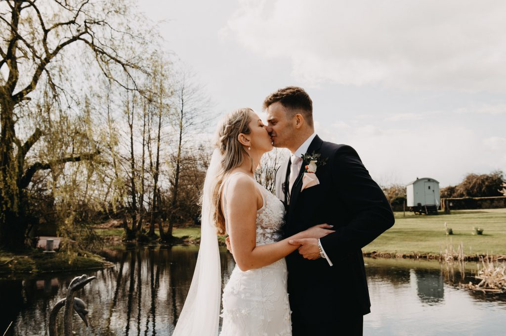Couple Share a Kiss During Wedding Portraits - Grittenham Barn Wedding 