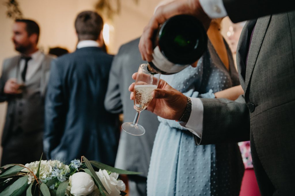 Candid Wedding Moments - Guest Pouring Champagne 