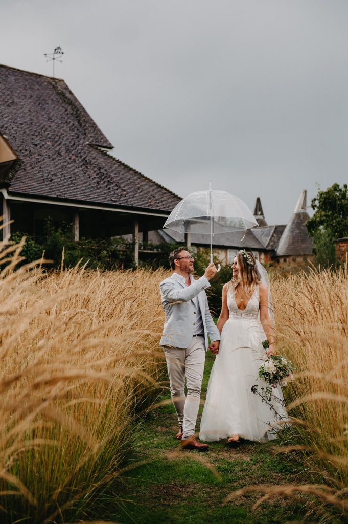 Couple Walk Together In Tall Grass for Relaxed Wedding Portraits