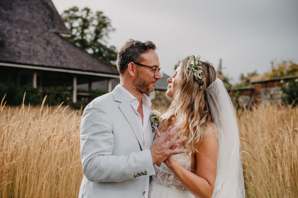 Relaxed and Candid Wedding Portrait in Fields of Bury Court Barn