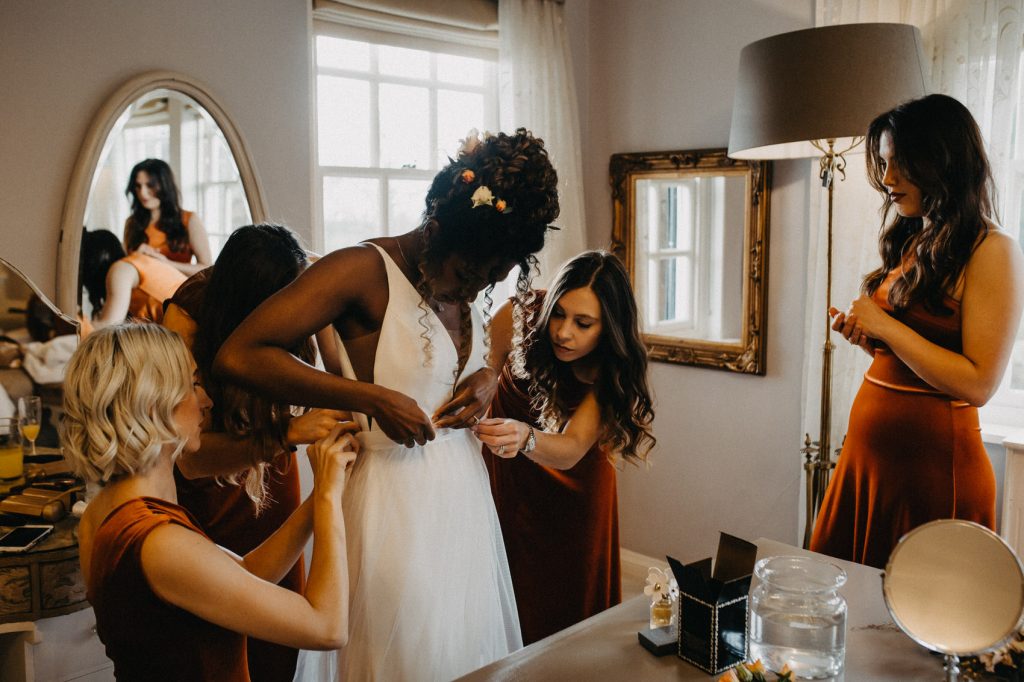 Wedding Party Help Bride into Her Gorgeous Savin Wedding Dress