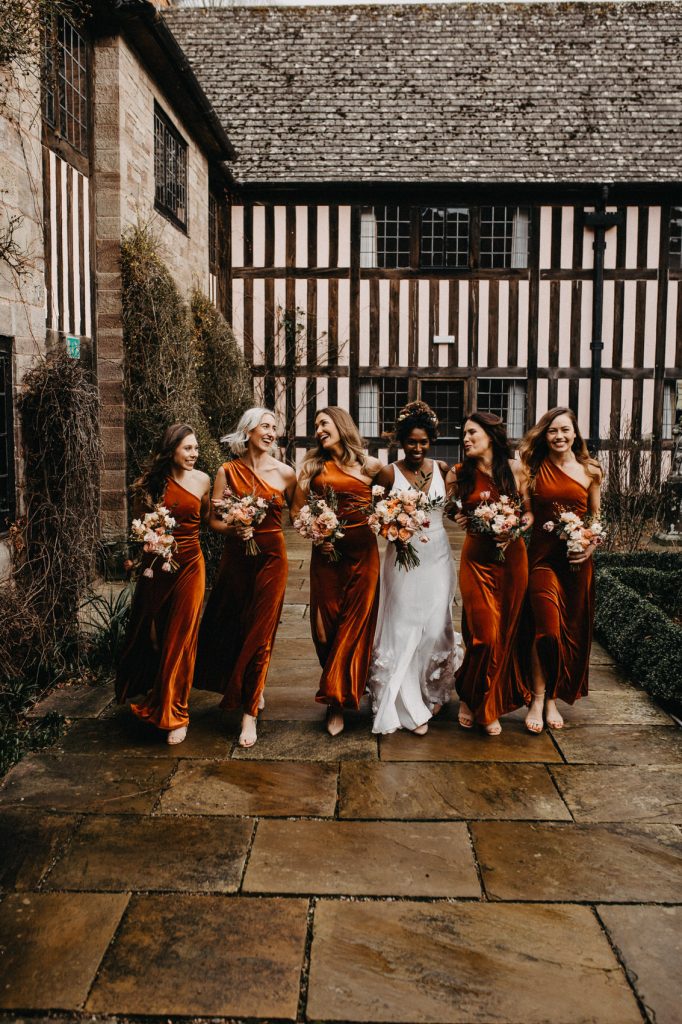 Bridesmaids Walk Together During Group Photography