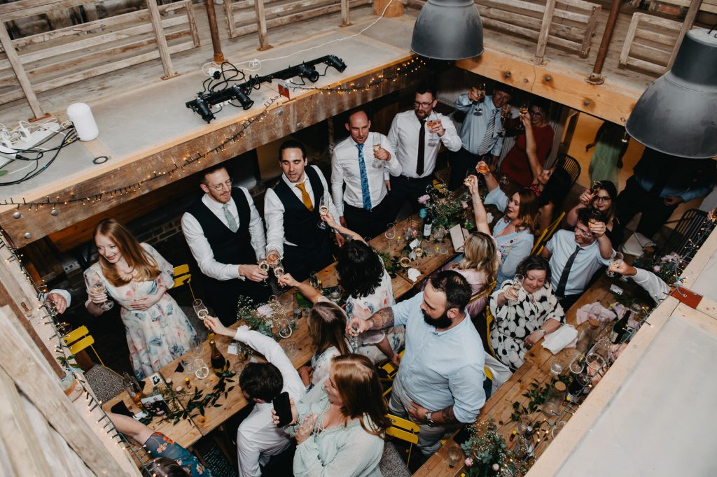 Guests Cheers Champagne Flutes During Speeches - Farnham Pottery Wedding