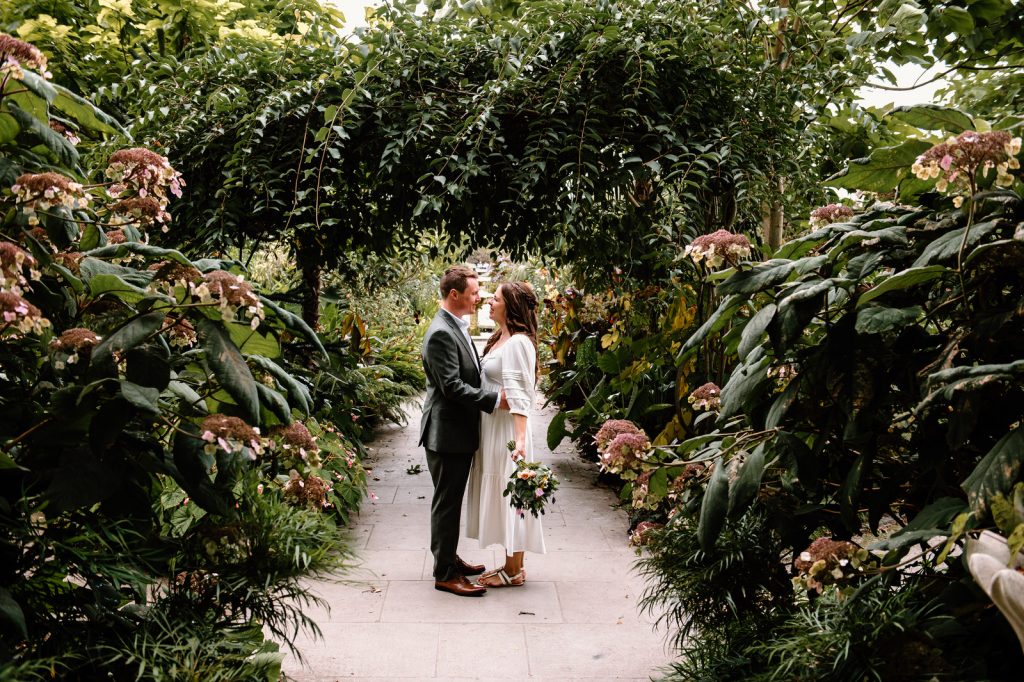 Couple Embrace in the Tropical Garden at RHS Wisley Gardens for Portraits