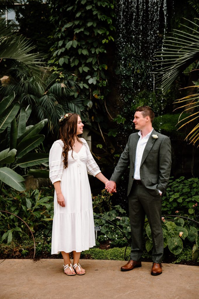 Couple Stand Naturally in Tropical Glasshouse - RHS Wisley Garden Wedding 