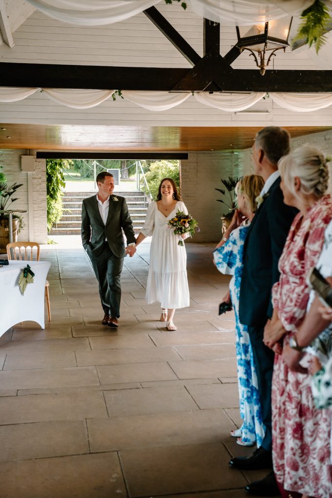 Couple Walk Together Down The Aisle for RHS Wisley Garden Wedding