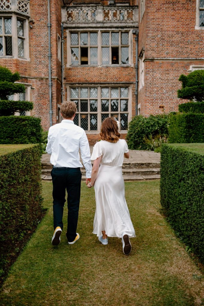 Couple Walk in The Gardens - Great Fosters Wedding