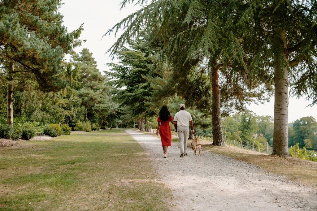 Couple Walk Together Down The Tree Lined Pathway at Painshill Park