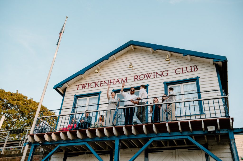 Guests Enjoy Sunset at Twickenham Rowing Club Wedding on Balcony 