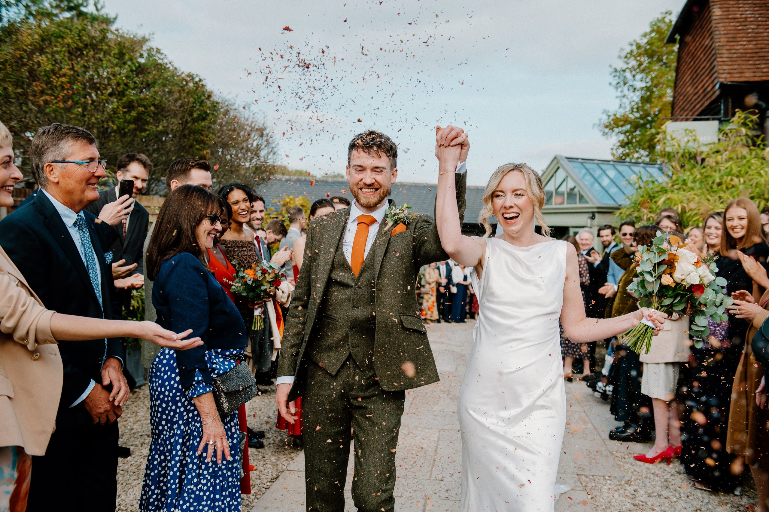 Couple Cheer Walking down Confetti Aisle - Surrey Wedding Photography