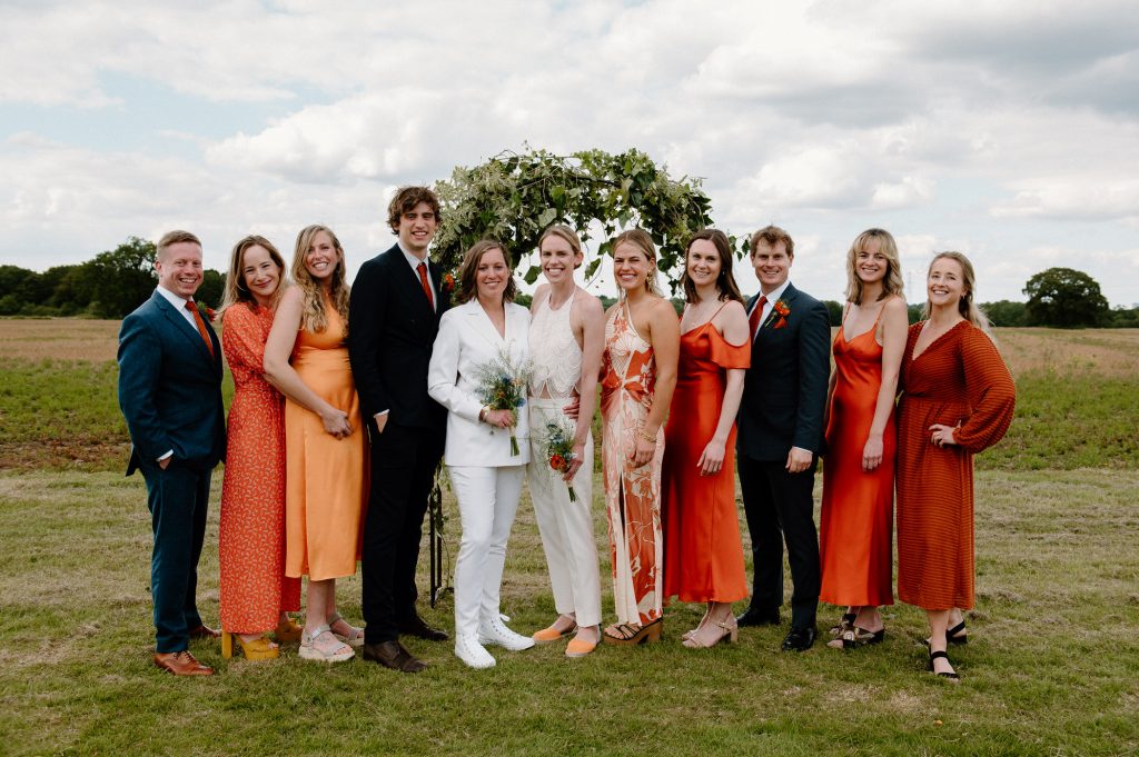 Bridal Party all Dressed in Miss Matching Outfits in Different Shades of Orange - Outdoor Barn Wedding