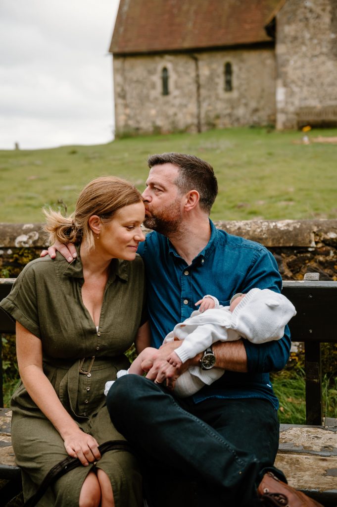 Relaxed and Candid Family Sit Together on Bench Outdoors - Newborn Family Photography